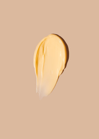 Yellow cosmetic smear of cream texture on a beige background. skincare. copyspace.の写真素材