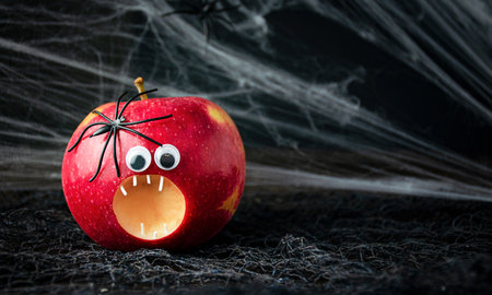 Halloween background. Scary apple with spiders on a dark background. Halloween food. Banner. copyspace.の写真素材