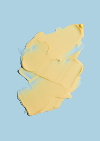 Yellow cosmetic strokes of cream texture on a blue background. skincare.の写真素材