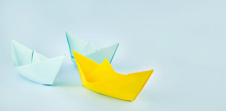 leadership concept. Paper boats on a blue background. business concept. Banner. copyspace.