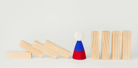 The concept of the domino effect, the fall of the Russian economy. A wooden man with the symbol of...