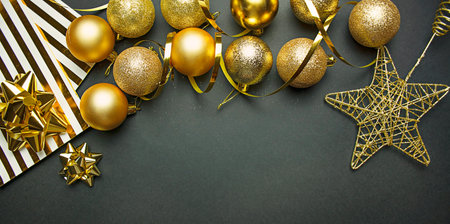 Christmas gold balls and decorations on a dark background. New Year decor. Christmas background....