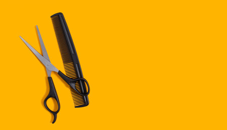 Barber scissors and a comb on a yellow background. Hair salon concept. Copy space. View from above.の写真素材