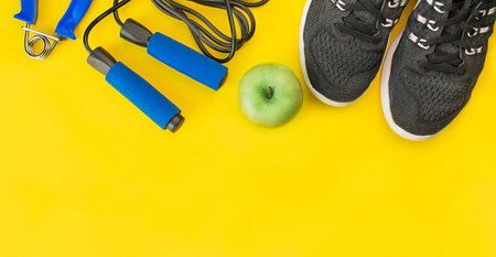 Healthy lifestyle. Sports equipment on a yellow background. Sport concept. Top view with copy space....