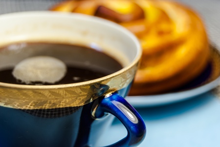 a delicious bun and a cup of coffee served on a tableの写真素材