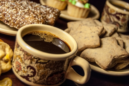 A cup of coffee and cookies on a tableの写真素材