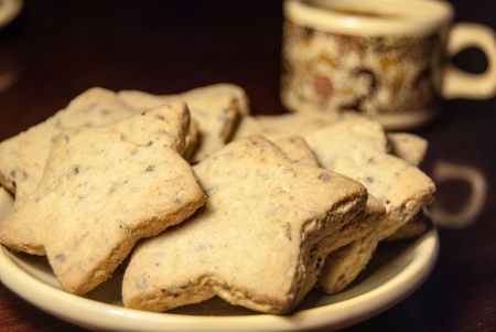 A cup of coffee and cookies on a tableの写真素材