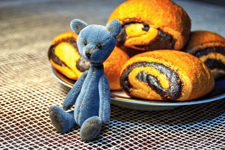 Poppy rolls on a dish and a small teddy bearの写真素材