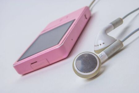 mp3 player with earphones on white backgroundの写真素材
