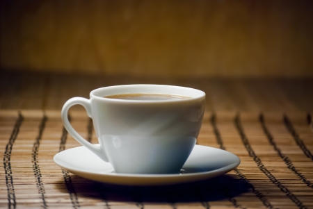 white cup of coffee on wooden matの写真素材