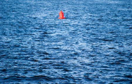 Flowing water surface with red buoyの写真素材