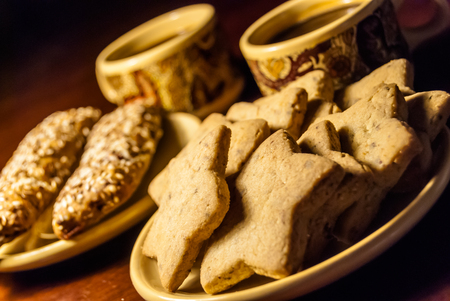 A cup of coffee and cookies on a tableの写真素材