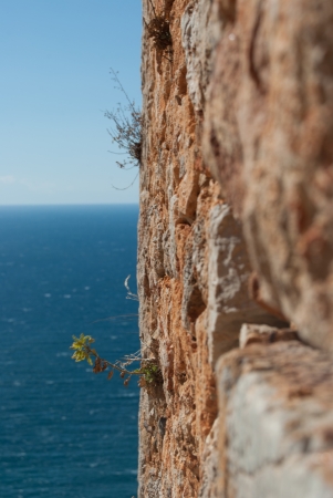 medieval stone battlement with sky and seaの写真素材