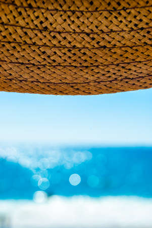 straw hat and sea on the beachの写真素材