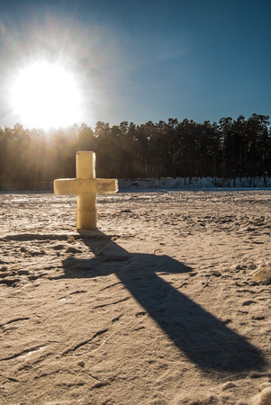 ice christian cross on frozen lakeの写真素材