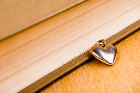 metallic heart near book