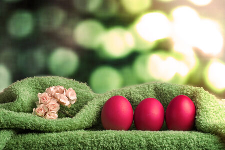 Easter decoration. Background with eggs and Turkish towel on green defocused backgroundの写真素材
