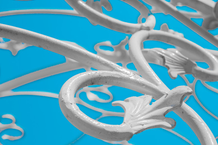 white forged plant ornament against blue skyの写真素材