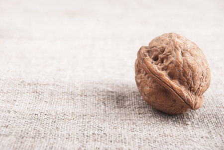 Three brown greek nuts on textured textile background