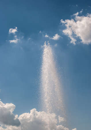 fontain against cloudy sky on sunny dayの写真素材