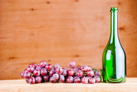 wine bottle with grapes on a wooden backgroundの写真素材