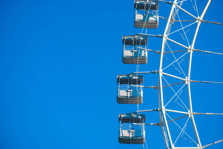 White ferris wheel against blue skyの写真素材