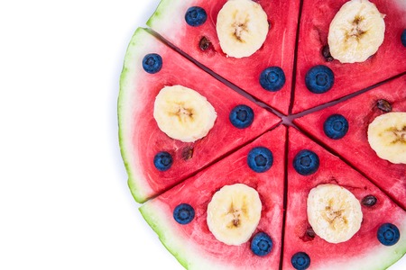 Sliced juicy watermelon pizza isolated on white, closeup view from above. Ingredients are watermelon, blueberries, banana.の写真素材