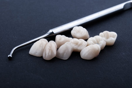 close up dental instruments and false teeth on black background