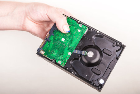 Female hand showing a Hard Drive on white