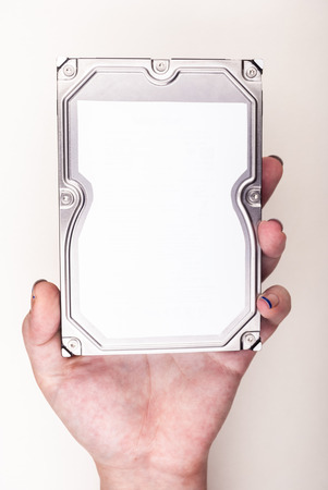 Female hand showing a Hard Drive on whiteの写真素材