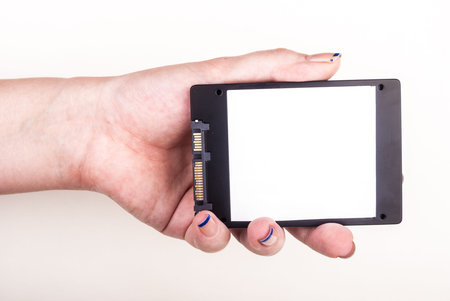 Female hand showing a Solid State Drive on white