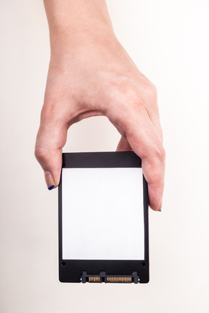 Female hand showing a Solid State Drive on whiteの写真素材