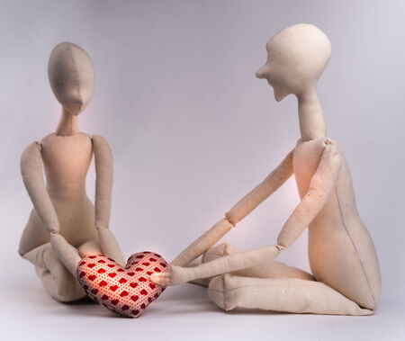 Two handmade textile dolls holding red heart. Image of love, affection.の写真素材