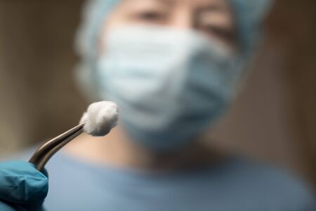 Female dentist with tools staring at a patientの写真素材