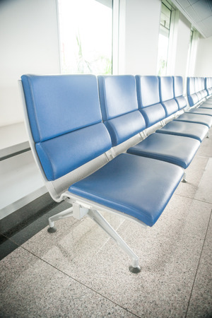 Airport waiting area with rows of blue seats. の写真素材