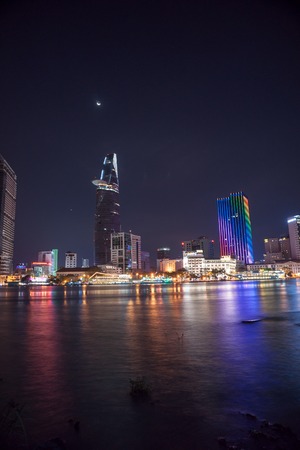 Cityscape of Ho Chi Minh at night with bright illumination of modern architecture, viewed over Saigon river in Southern Vietnam.のeditorial素材