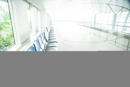 Airport waiting area with rows of blue seats. のeditorial素材
