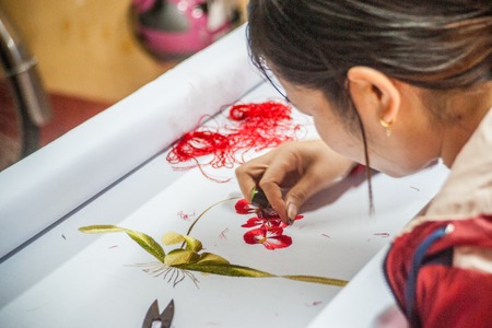 HOI AN, VIETNAM - FEBRUARY 5, 2015: Vietnamese woman produces hand-made embroidery, in Hoi An, Feb 5, 2015.のeditorial素材