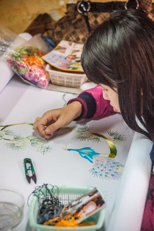 HOI AN, VIETNAM - FEBRUARY 5, 2015: Vietnamese woman produces hand-made embroidery, in Hoi An, Feb 5, 2015.のeditorial素材