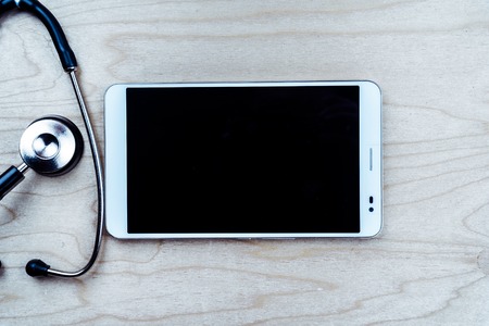 Stethoscope with a tablet computer on wooden table. Medical backgroundの写真素材