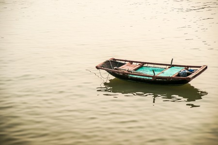 Solitary boat on the sea surface at sunsetの写真素材