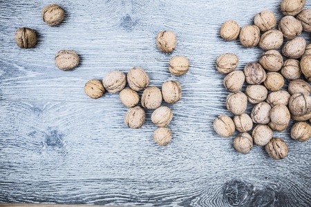 Plenty of walnuts on wood. Image of harvest, autumn, and vegetarian food. Raw food texture. Rural texture background.の写真素材