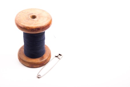 Big vintage spool of thread with needle isolated on white. Symbol of handmade, clothes and needlework.の写真素材