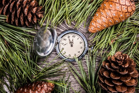 Christmas background with clock among fir tree, and cones. Image for banners, Advertising, and blogs.の写真素材