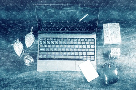 Black laptop on wood with christmas decoration and giftboxes and bank card viewed from above. Image for internet shopping, electronic banking and web payment.の写真素材
