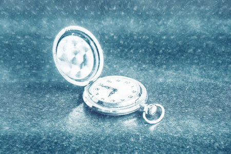 Vintage pocket watch on wooden desk. Symbol of time, deadlines, and rush. Conceptual background...