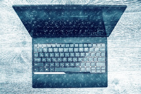 Black laptop on wood viewed from above.の写真素材