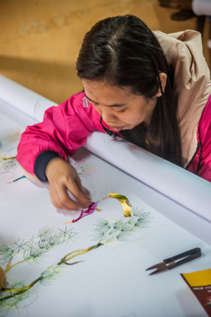 HOI AN, VIETNAM - FEBRUARY 5, 2015: Vietnamese woman produces hand-made embroidery, in Hoi An, Feb 5, 2015.のeditorial素材