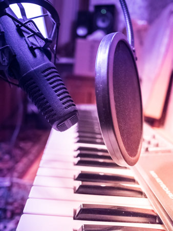 Electronic piano with microphone. Musical background image. Recording studio equipment.