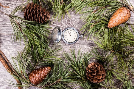 Christmas background with clock among fir tree, and cones. Image for banners, Advertising, and blogs.の写真素材